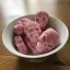 Eine weiße Schale, gefüllt mit rosa Bonbons in Totenkopfform.